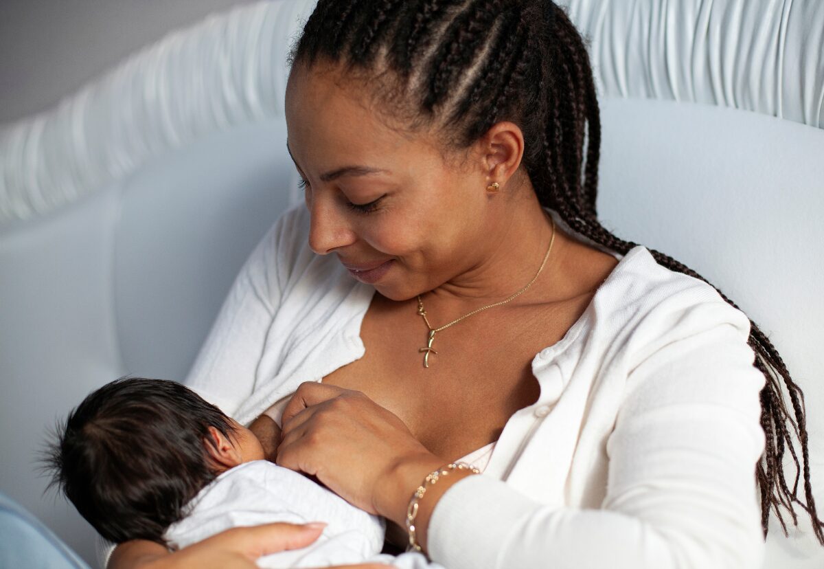 Mãe amamentando o bebê com expressão de ternura.